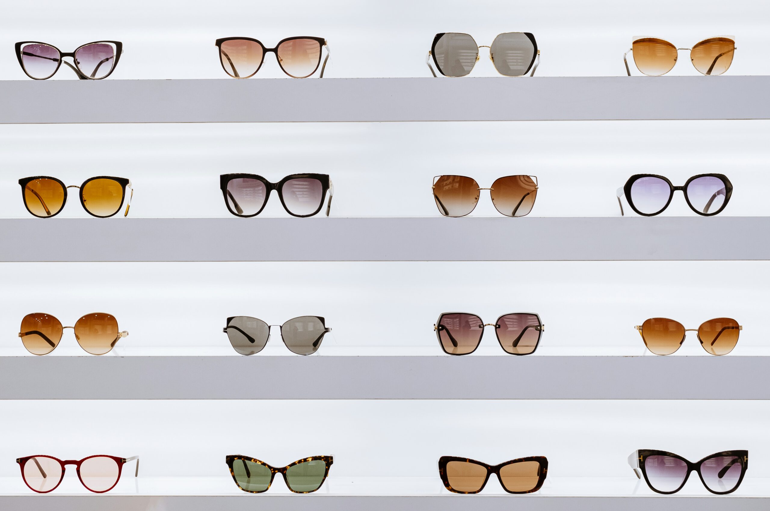 A display of various eyewear frames showing a retail comparison of Specsavers vs Vision Express vs Glasses Direct.