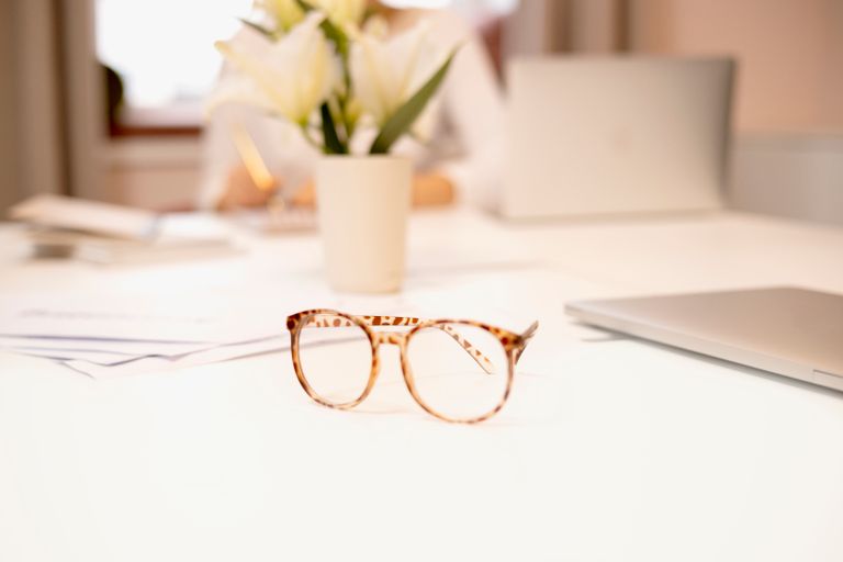 Eyewear maintenance accessories including an ultrasonic cleaner and glasses on a desk