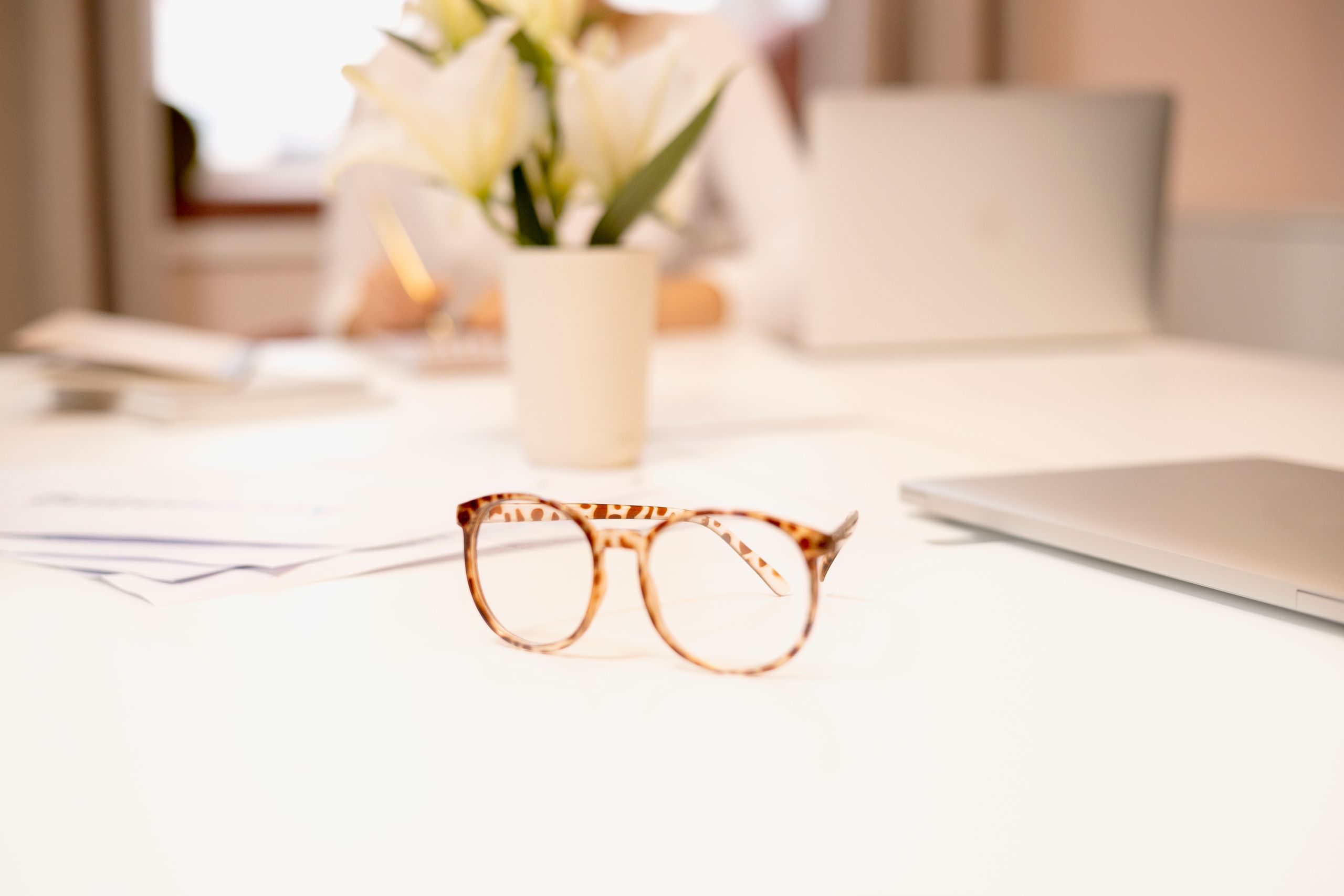 Eyewear maintenance accessories including an ultrasonic cleaner and glasses on a desk