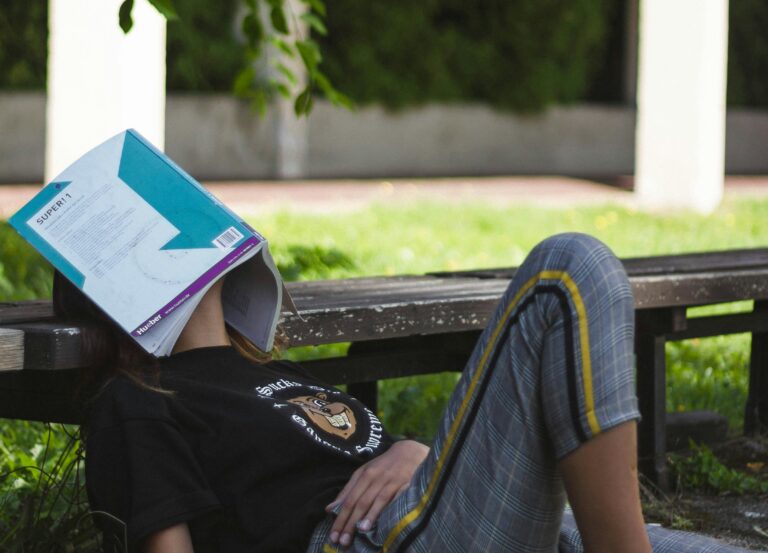 A student taking a break from reading, highlighting why blue light glasses for students aren't always the solution to screen fatigue.