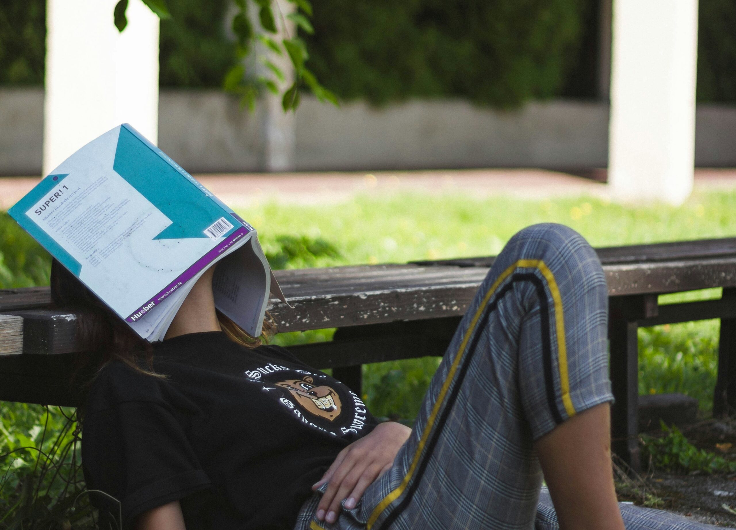 A student taking a break from reading, highlighting why blue light glasses for students aren't always the solution to screen fatigue.